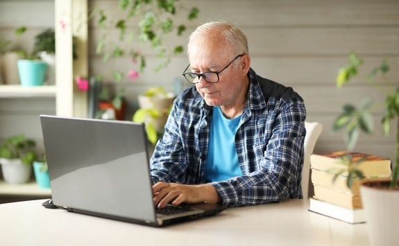  Man accessing his pension using laptop